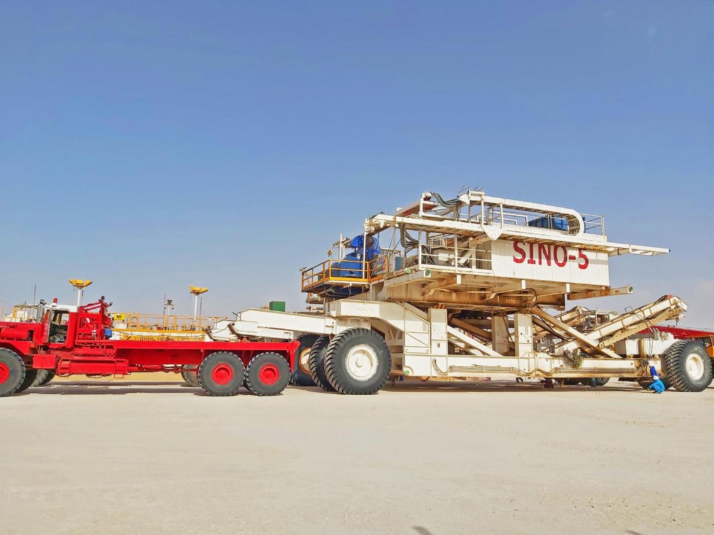 Red 953 Super Kenworth pulling a derrick dolly with a rig section